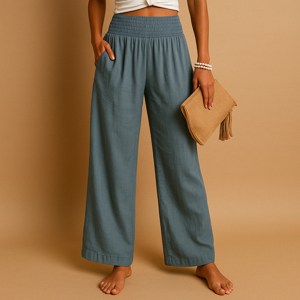 Pantaloni larghi donna blu, vita alta elasticizzata, tasche laterali, abbinati a top bianco e pochette beige. Moda casual estiva.