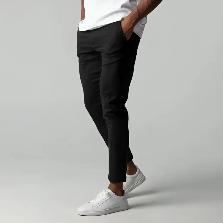 Pantaloni neri eleganti da uomo, vestibilità slim, abbinati a scarpe da ginnastica bianche, moda casual, stile moderno, abbigliamento maschile.
