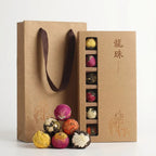 Brown paper bag with colorful tea balls and a box of tea balls on a white background
