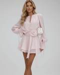 Model wearing Lauven Florence Mini Dress in soft pink with 3D embellishments and flare sleeves.